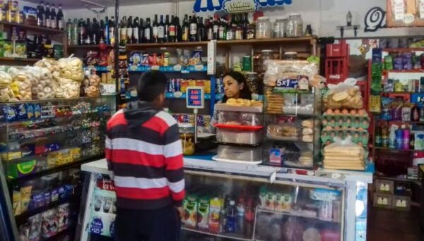 Estanterías de un almacén de barrio con productos y precios visibles