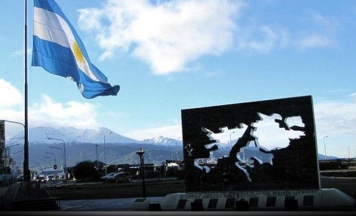 Veteranos de guerra con banderas argentinas en un acto conmemorativo