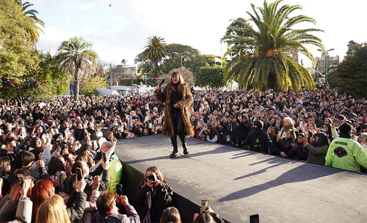 Moria Casán recibiendo una placa en un escenario al aire libre