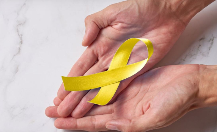 Lazo amarillo de concientización sobre fondo oscuro, símbolo de la prevención del suicidio