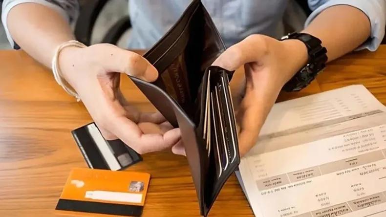 Persona revisando billetes y tarjetas en una mesa